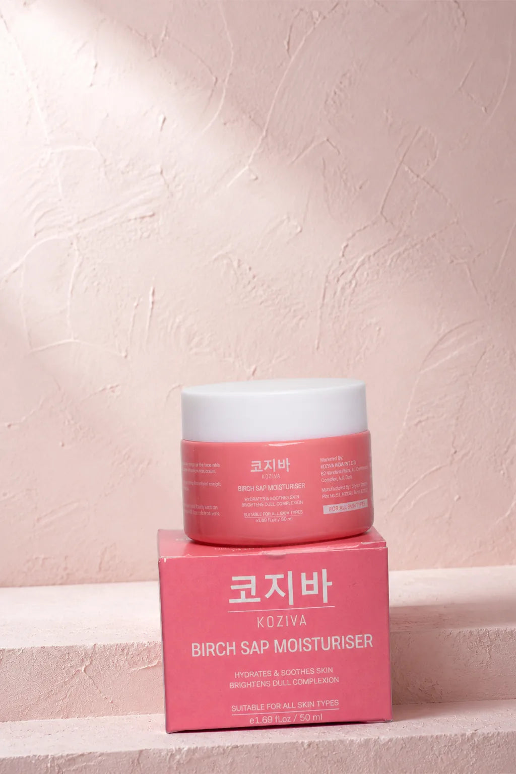 The Koziva birch sap moisturiser and its carton on a pale ledge in soft daylight