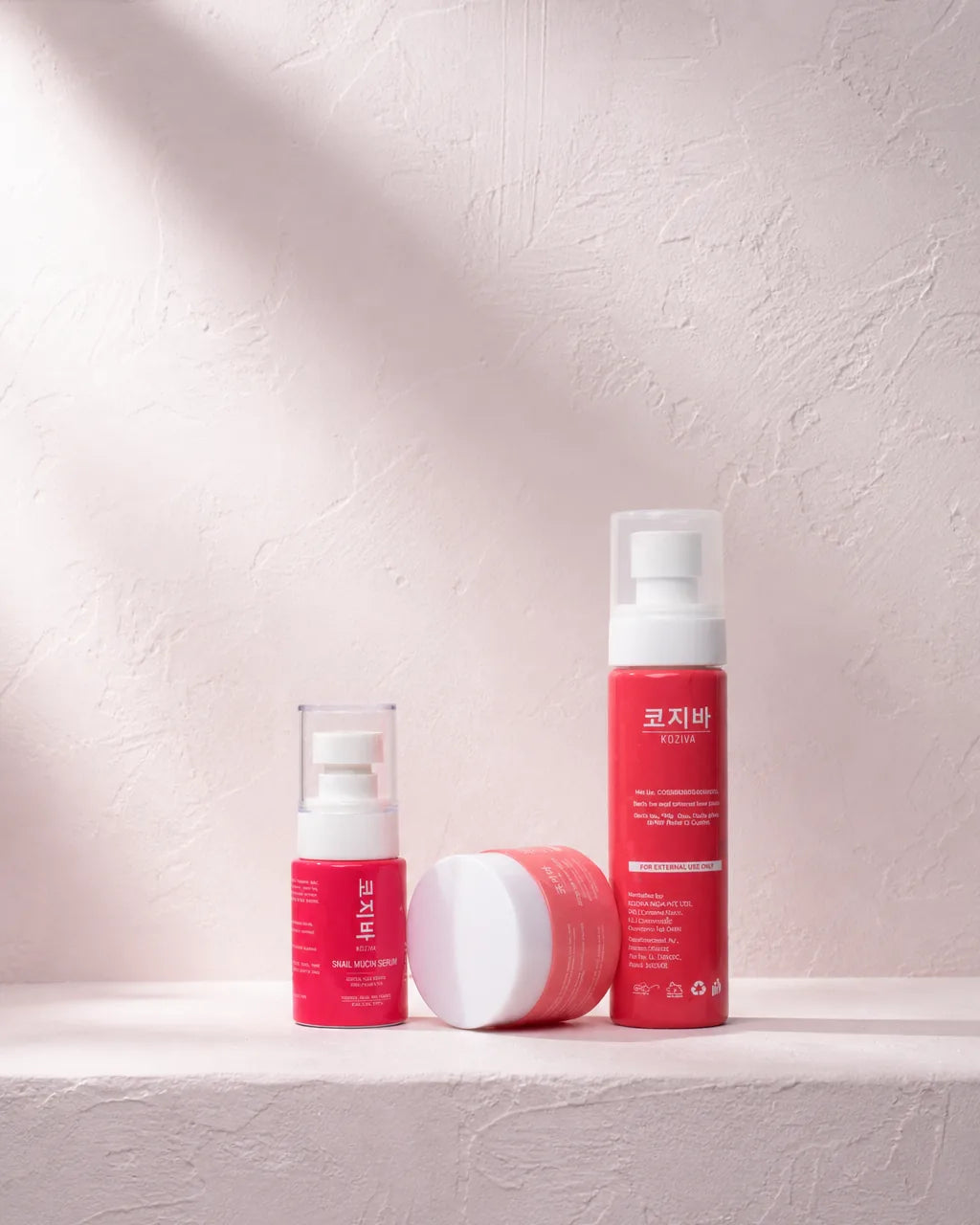 The Koziva rice toner, snail mucin serum and birch sap moisturiser standing together on a pale ledge