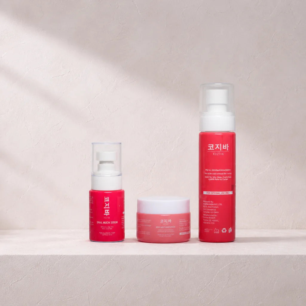All three Koziva products grouped on a pink plaster ledge in soft daylight